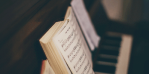 A book of sheet music open on a piano