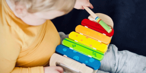 A child plays on a toy xylophone